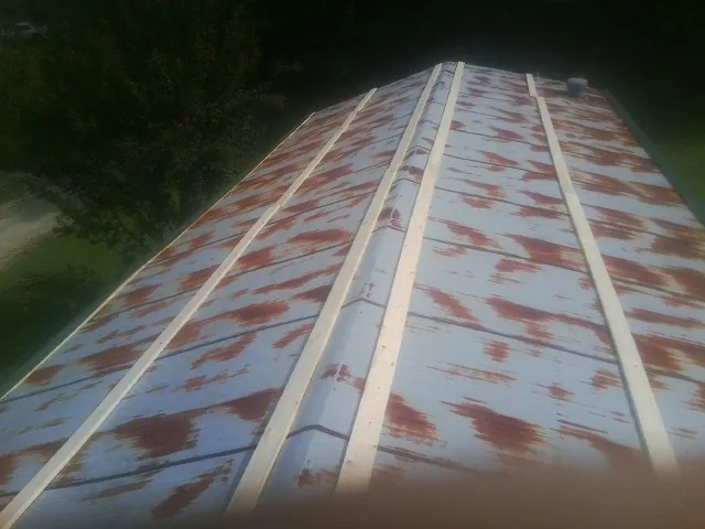 Rusted metal roof panels with new wood purlins before replacement — Storm Damage Roof Repair in Bethune by Roofing Brothers